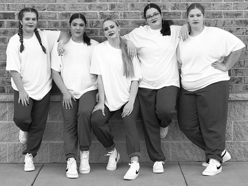 Five dancers in white t-shirts and sweats